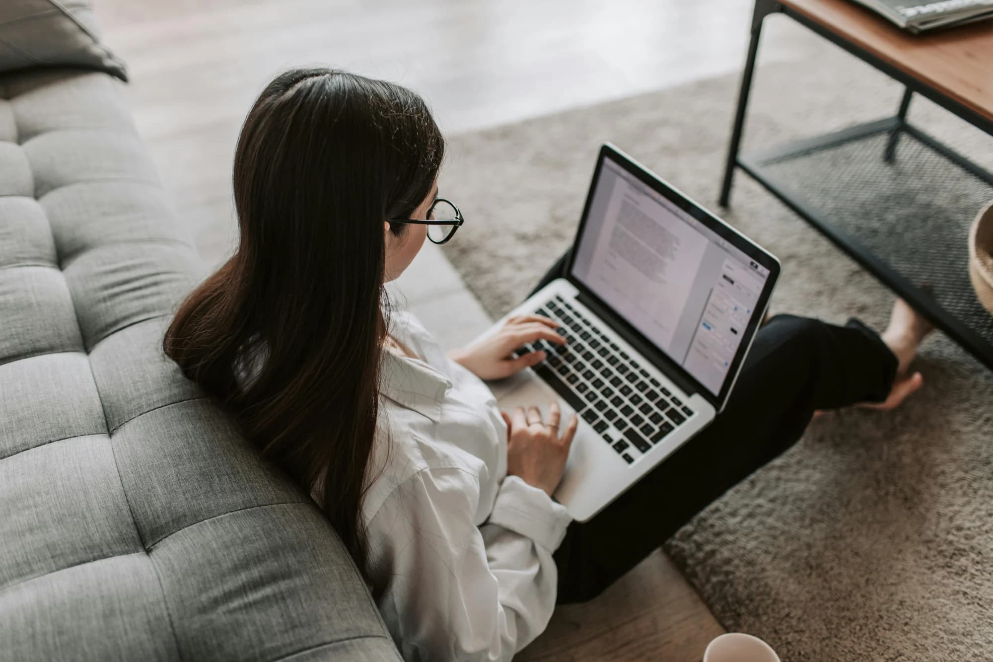 Person working with a laptop from a sofa